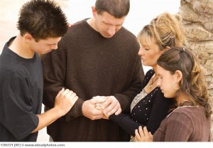 A group of young people praying together